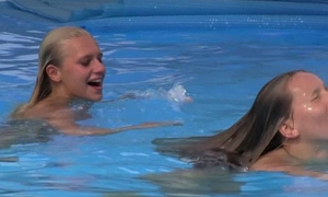 Two beautiful girls swimming increased by licking by the pool